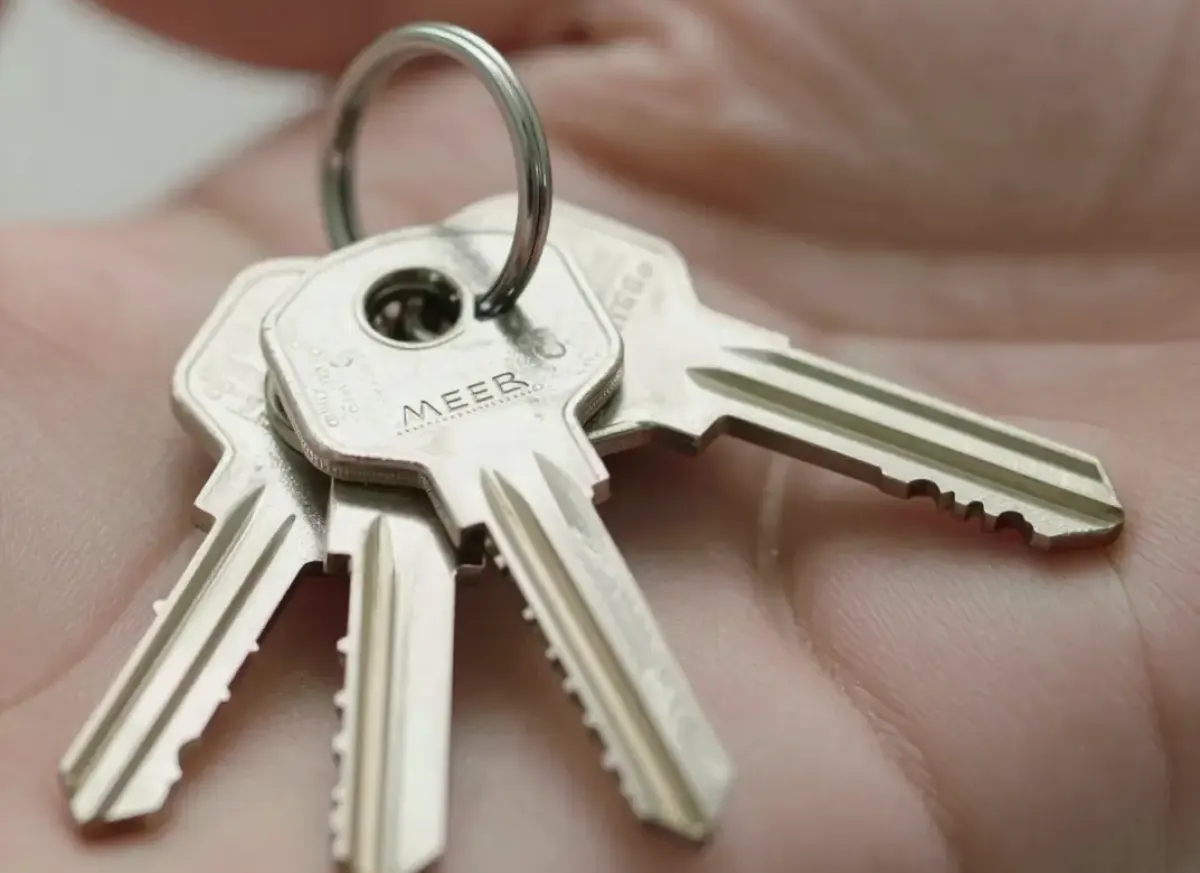 Kleiner Ring mit gleich geformten Sicherheitsschlüsseln einer Schließanlage auf einer offenen Hand
